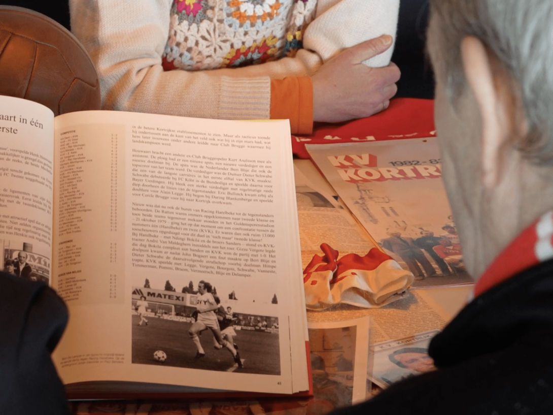 Supporter KV Kortrijk leest in geschiedenisboek