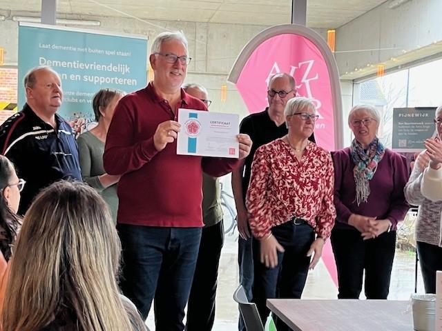 clubafgevaardigde toont certificaat dementievriendelijke sportclub